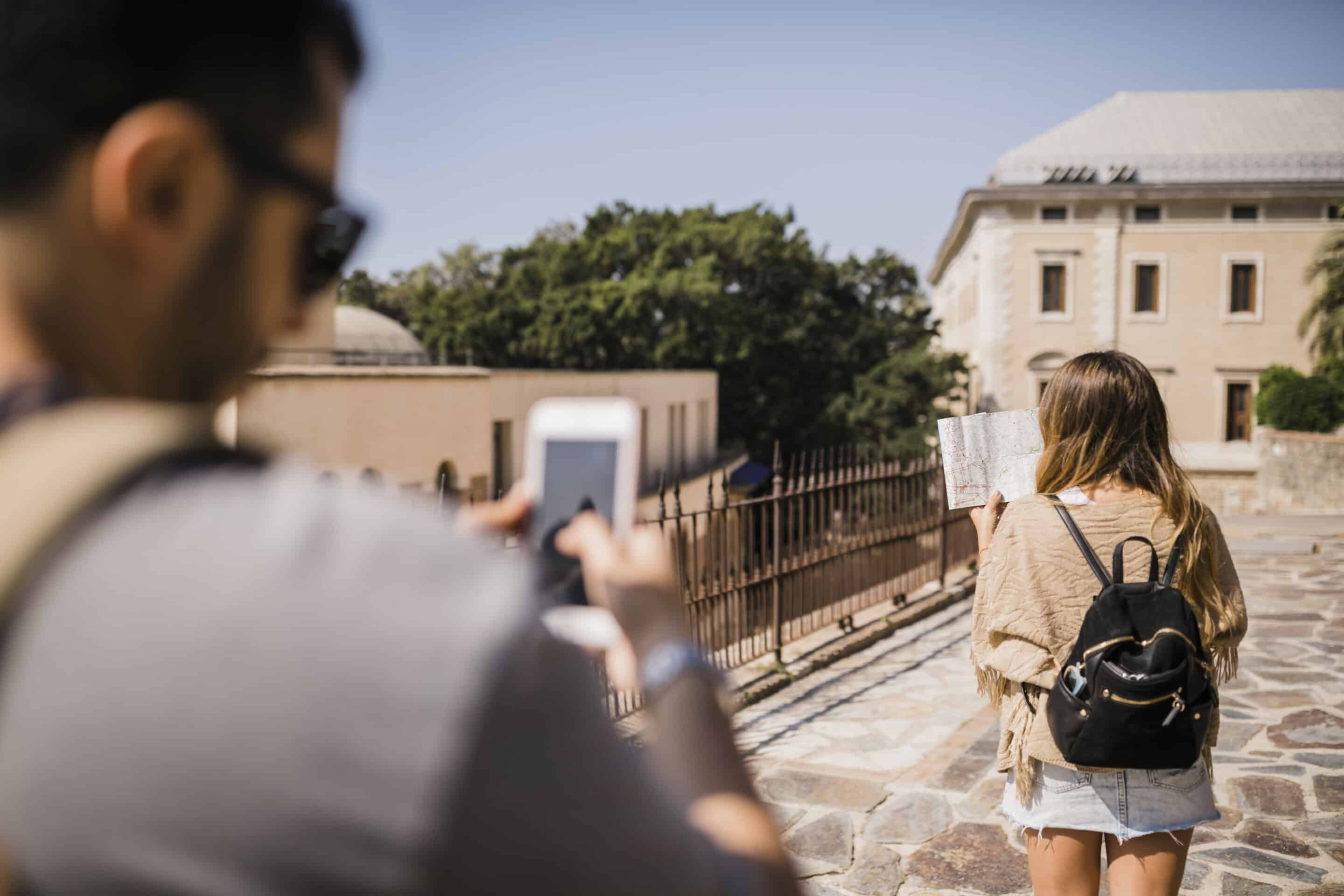 Touristes à Montpellier explorant la ville avec une carte, illustration d'un voyage sécurisé grâce à une assurance tourisme Montpellier<br />
